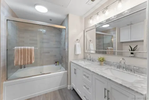 a bathroom with a granite countertop sink mirror and bathtub