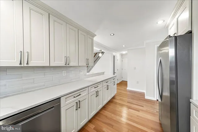 a kitchen with white cabinets and stainless steel appliances