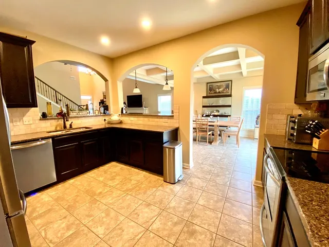 a kitchen with stainless steel appliances kitchen island granite countertop a sink and cabinets