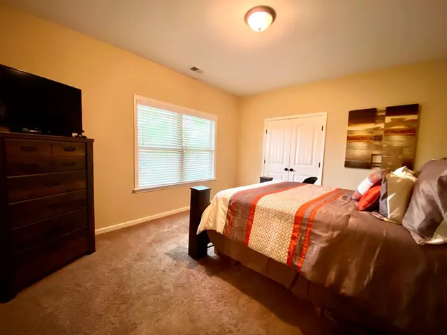 a bed sitting in a bedroom next to a window