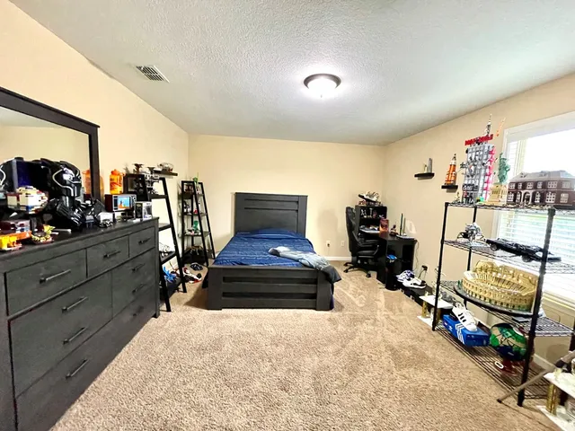 a bedroom with furniture and a flat screen tv