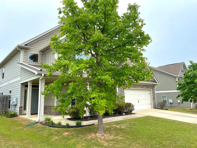 a front view of a house with a yard garage and outdoor seating