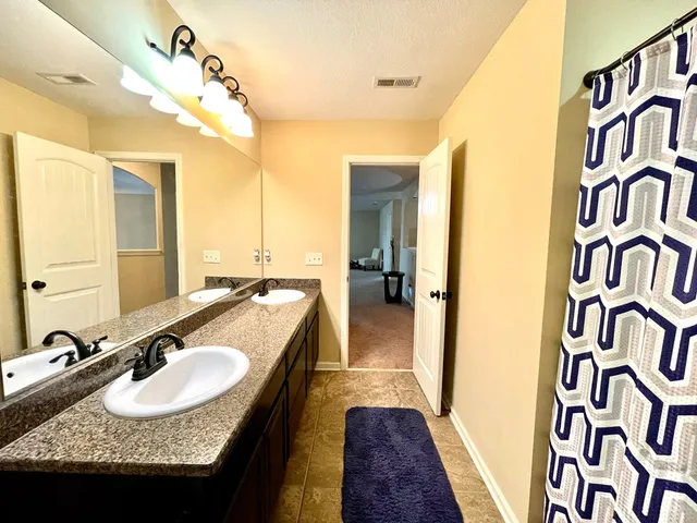 a bathroom with a granite countertop sink and a mirror