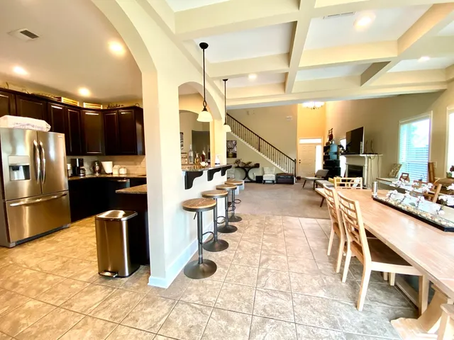 a kitchen with stainless steel appliances kitchen island granite countertop a refrigerator and a sink