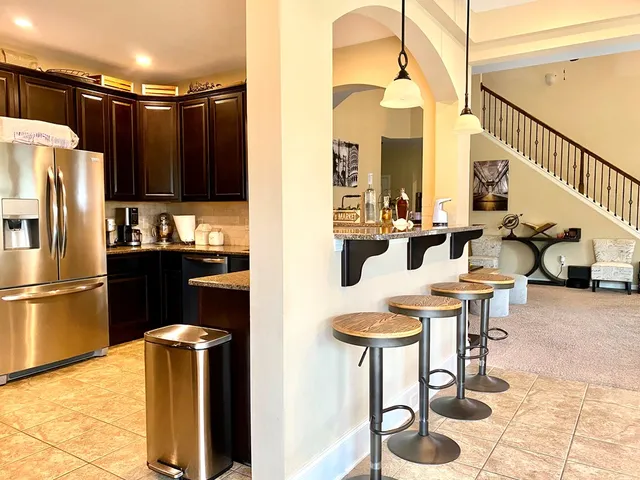 a kitchen with stainless steel appliances kitchen island granite countertop a refrigerator and a stove