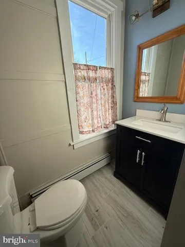a bathroom with a granite countertop toilet sink and mirror