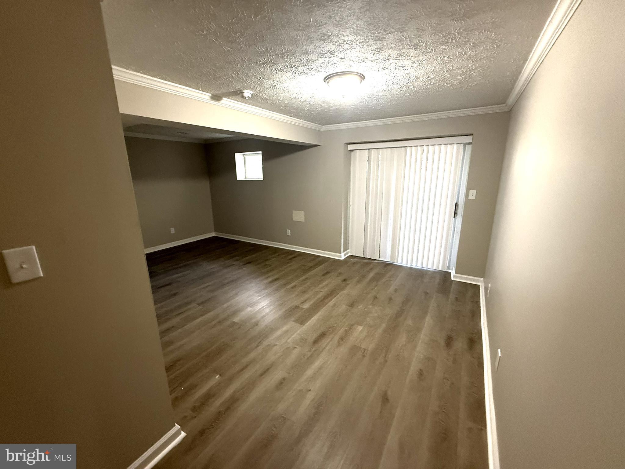 7604 Fox Hunt Court Clinton, MD 20735 - Photo 11 of 14 an empty room with wooden floor and windows