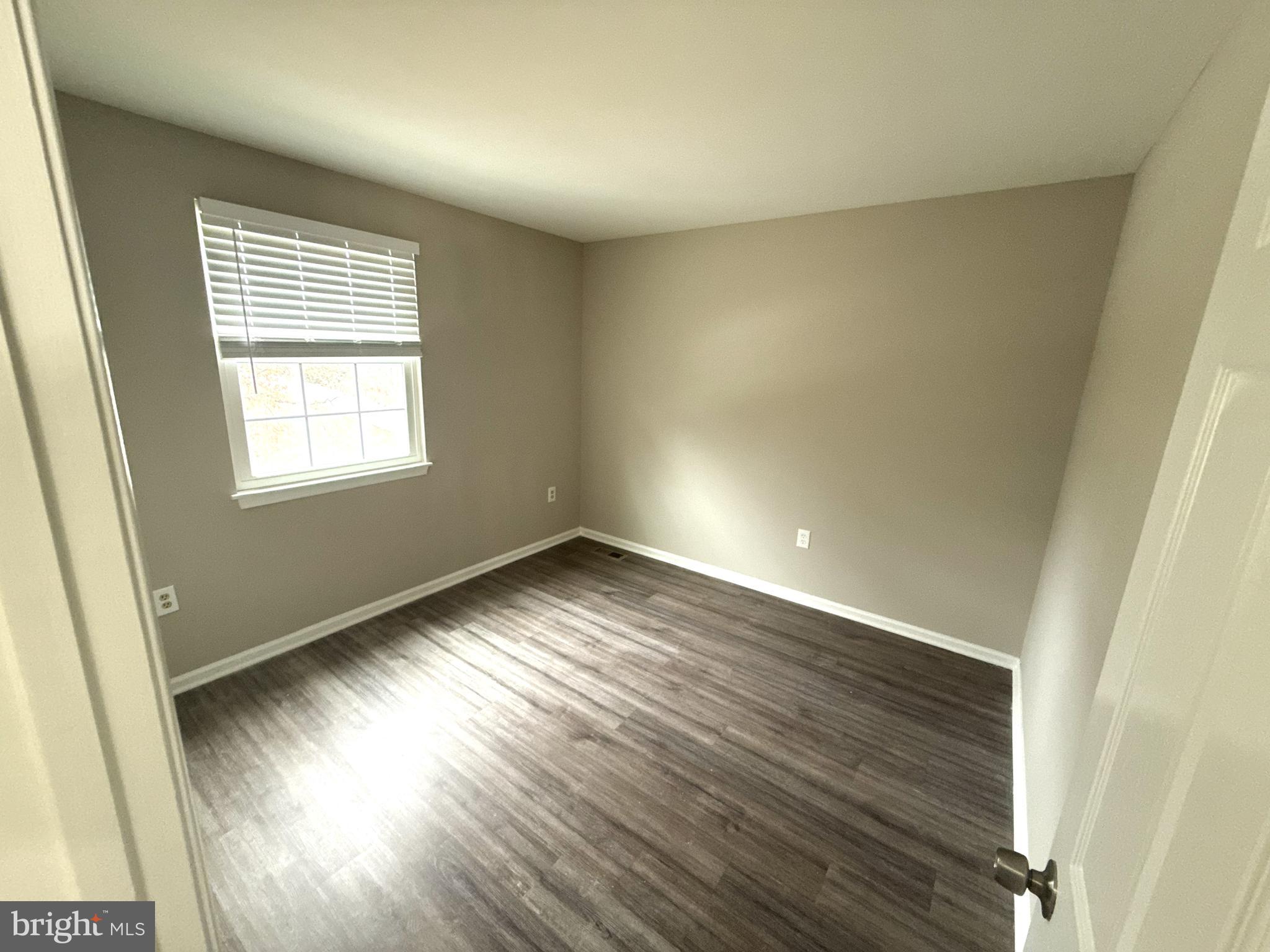 7604 Fox Hunt Court Clinton, MD 20735 - Photo 9 of 14 an empty room with wooden floor and windows