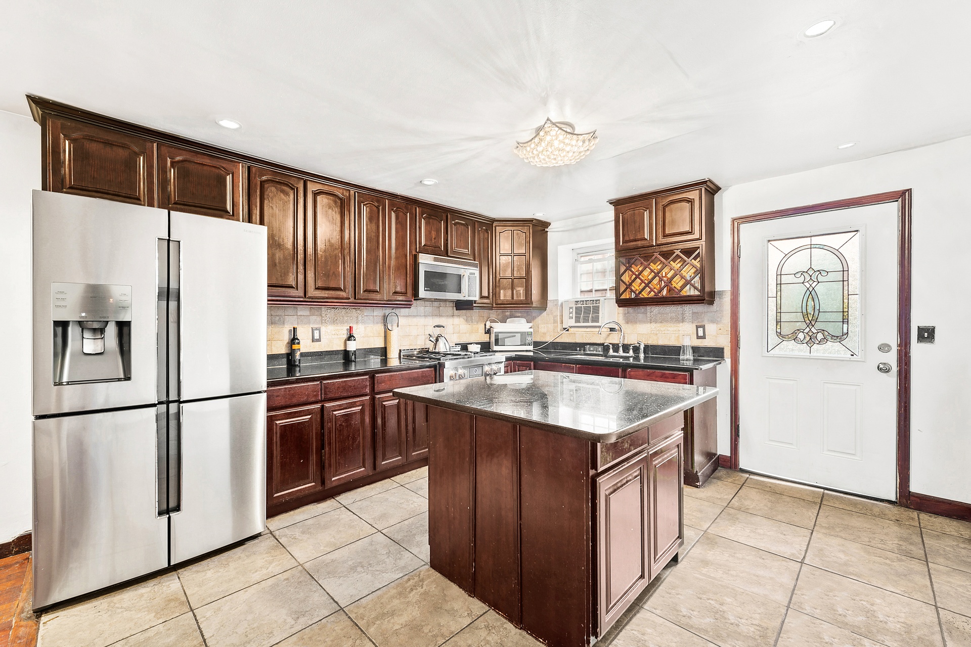 147 Patchen Avenue Brooklyn, NY 11221 - Photo 2 of 5 a kitchen with stainless steel appliances granite countertop a refrigerator stove sink and cabinets