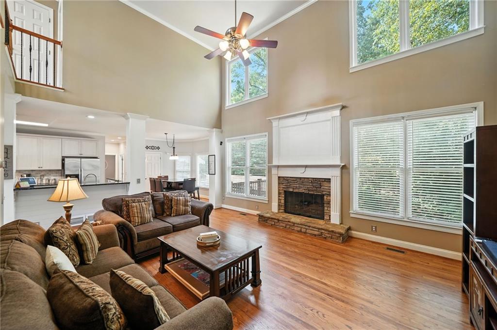 629 Gold Valley Pass Canton, GA 30114 - Photo 12 of 110 a living room with furniture a fireplace and a floor to ceiling window