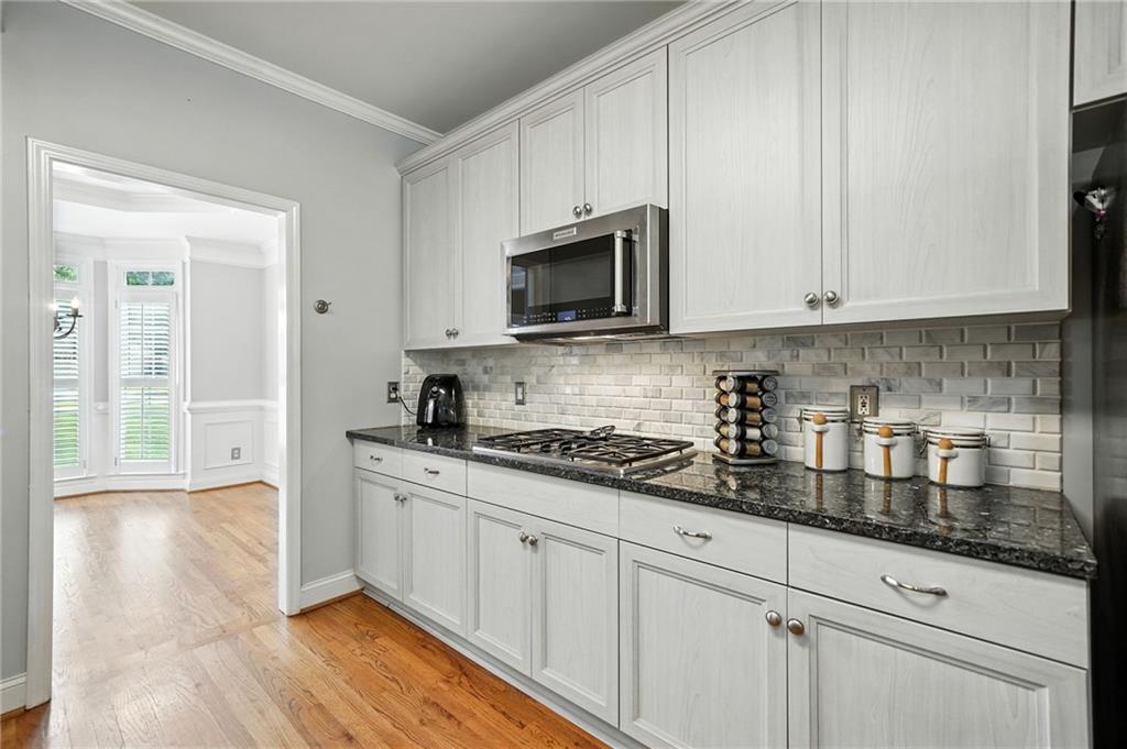 629 Gold Valley Pass Canton, GA 30114 - Photo 15 of 110 a kitchen with granite countertop white cabinets and a stove with wooden floor