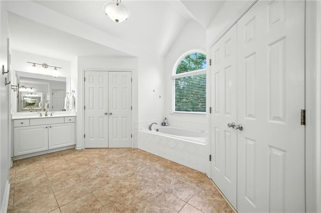 629 Gold Valley Pass Canton, GA 30114 - Photo 29 of 110 a spacious bathroom with a granite countertop sink a mirror a bathtub and a shower