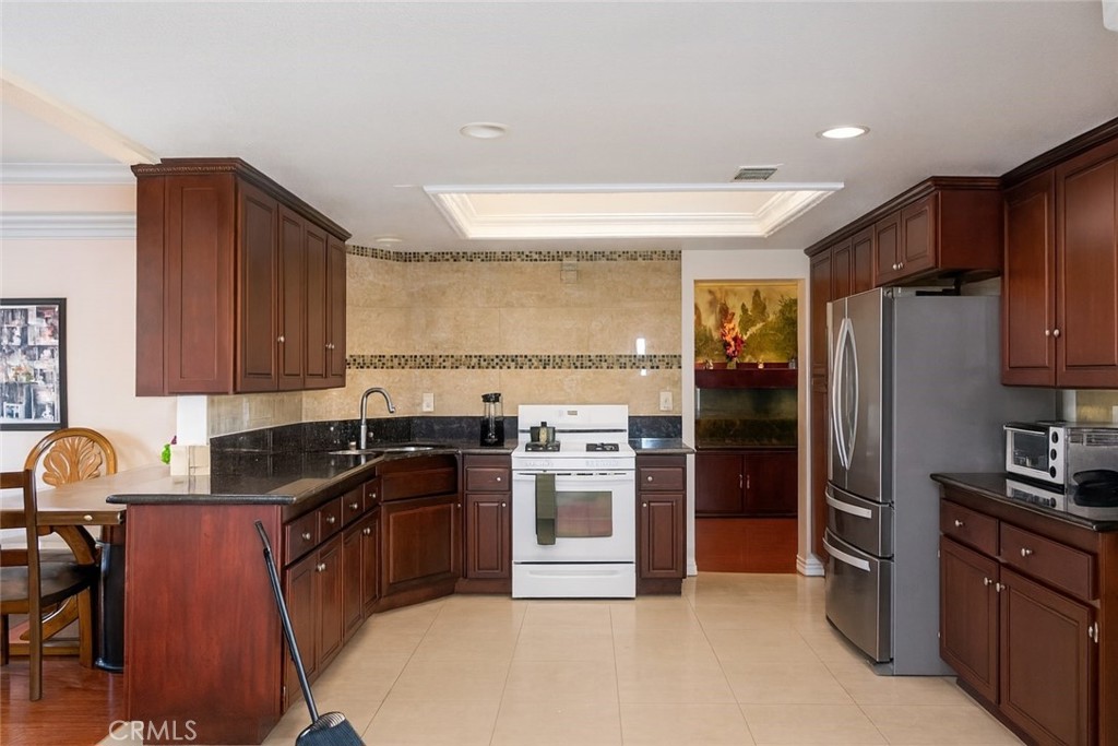 390 Dylan Circle Corona, CA 92879 - Photo 4 of 8 a kitchen with granite countertop a sink stainless steel appliances and cabinets