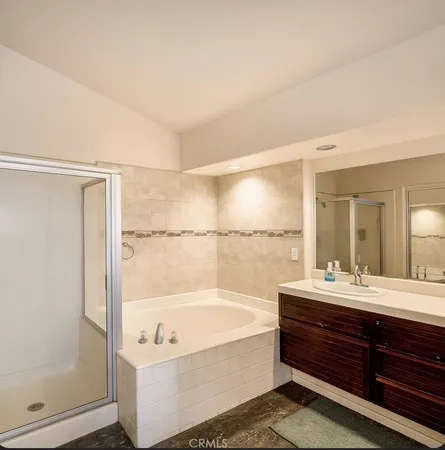 a bathroom with a tub sink shower and mirror