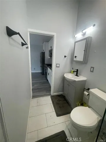 a white toilet sitting next to a bathroom sink and a mirror