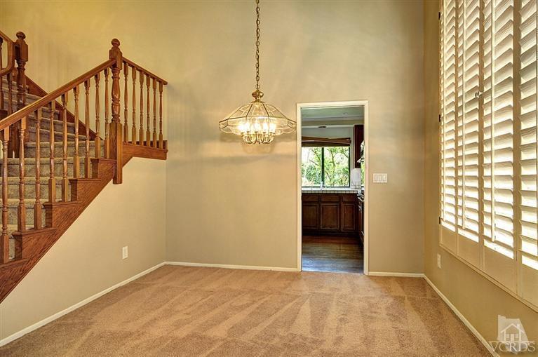 540 Fresh Meadows Road Simi Valley, CA 93065 - Photo 7 of 32 a view of a hallway with wooden floor and a chandelier