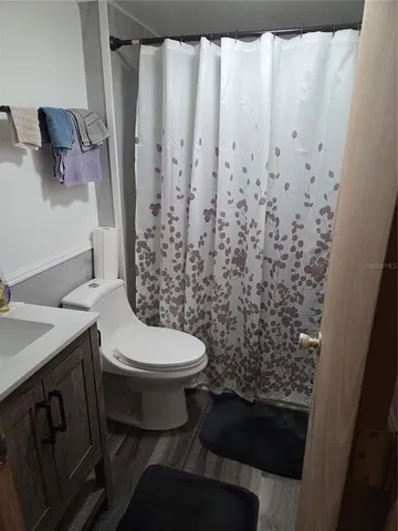 a bathroom with a toilet and a shower curtain