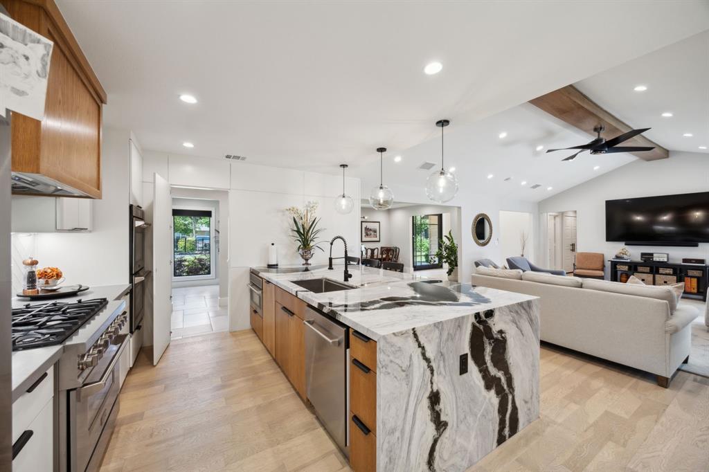 14406 Overview Drive Dallas, TX 75254 - Photo 8 of 39 a large kitchen with stainless steel appliances a stove a sink dishwasher and a dining table with the living room view