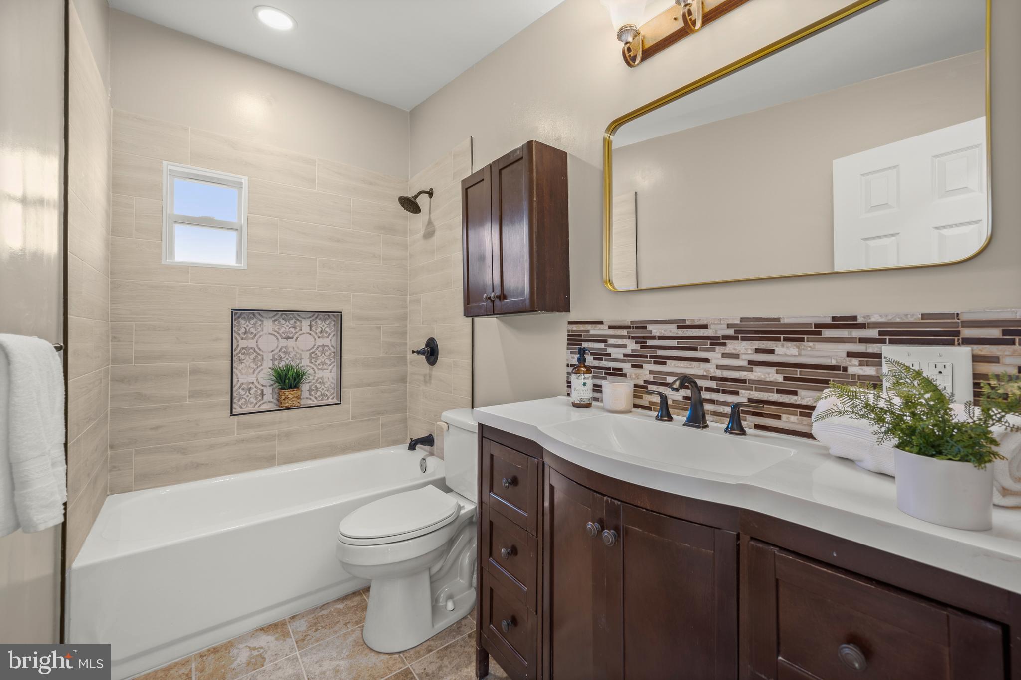 3412 Milford Mill Road Baltimore, MD 21244 - Photo 17 of 28 a bathroom with a sink a toilet and a bathtub