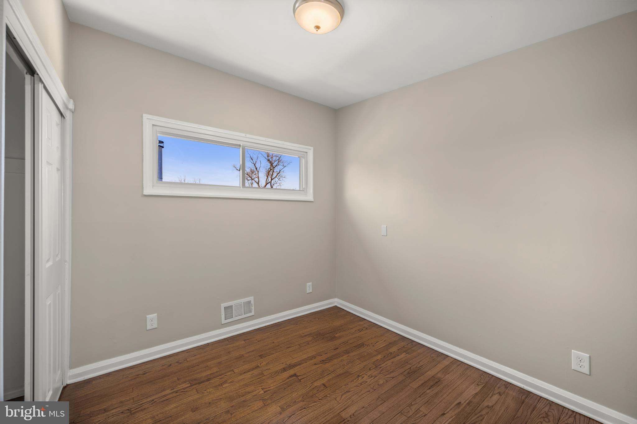3412 Milford Mill Road Baltimore, MD 21244 - Photo 18 of 28 a view of an empty room with wooden floor and a window