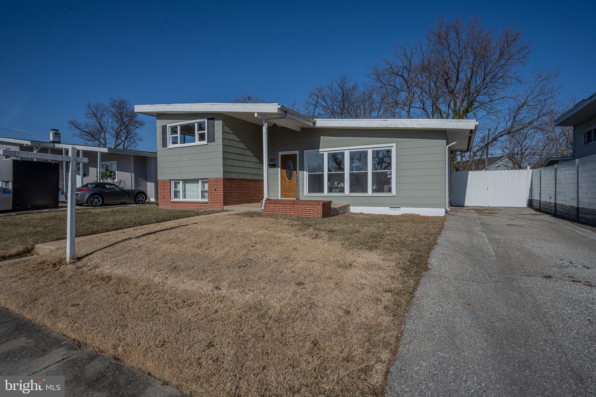 3412 Milford Mill Road Baltimore, MD 21244 - Photo 2 of 28 a front view of a house with a yard and garage