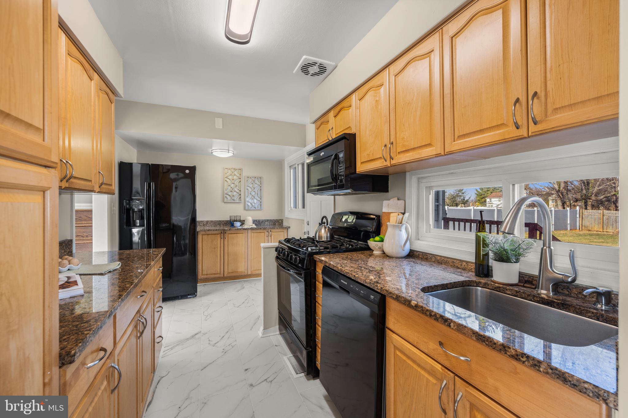 3412 Milford Mill Road Baltimore, MD 21244 - Photo 9 of 28 a kitchen with granite countertop a sink a counter top space stainless steel appliances and cabinets