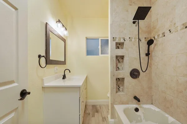 a bathroom with a tub sink and mirror