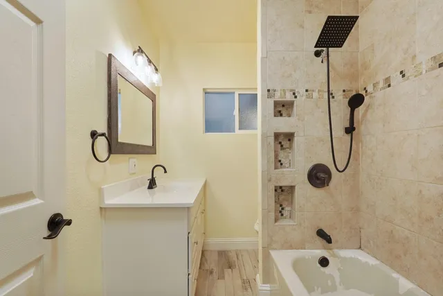 a bathroom with a tub sink and mirror