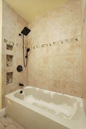 a bathroom with a tub a sink and a shower