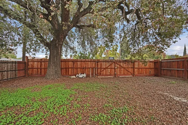 a view of backyard with wooden fence