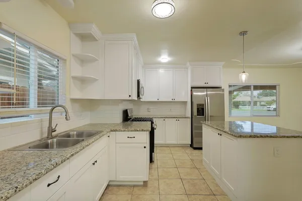 a kitchen with a sink cabinets and window