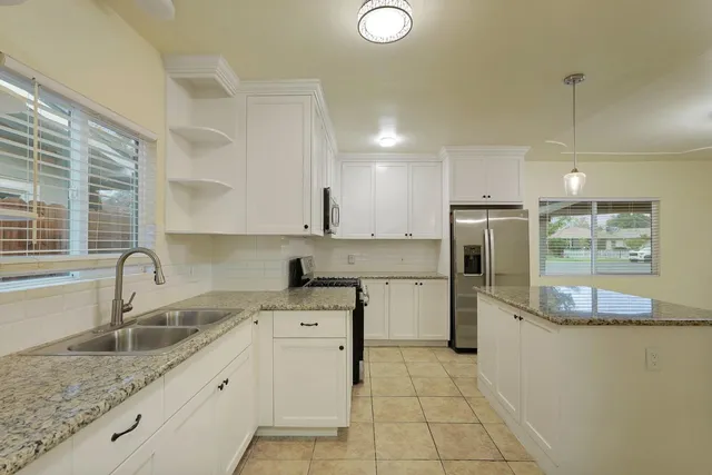 a kitchen with a sink cabinets and window