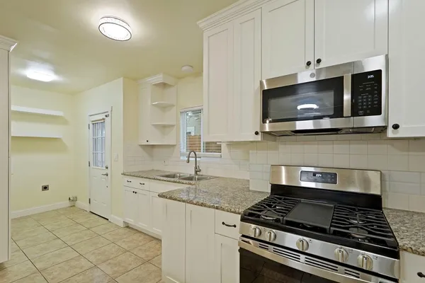 a kitchen with stainless steel appliances granite countertop a stove and a microwave