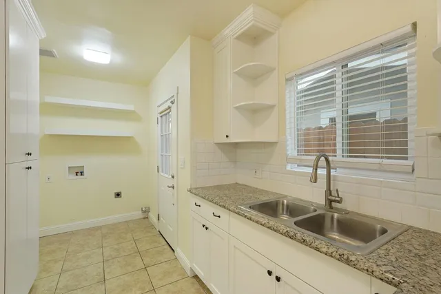 a kitchen with granite countertop a sink and a wooden floors
