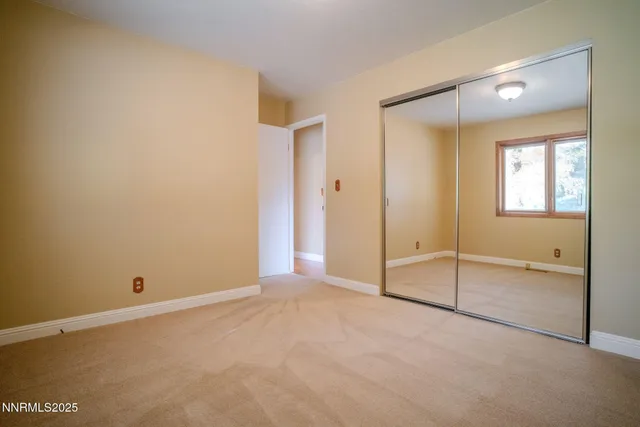an empty room with windows and closet