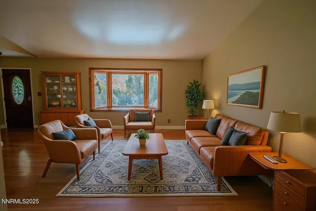 a living room with furniture a rug and a window
