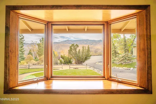 a view of a room that has a large window with front door