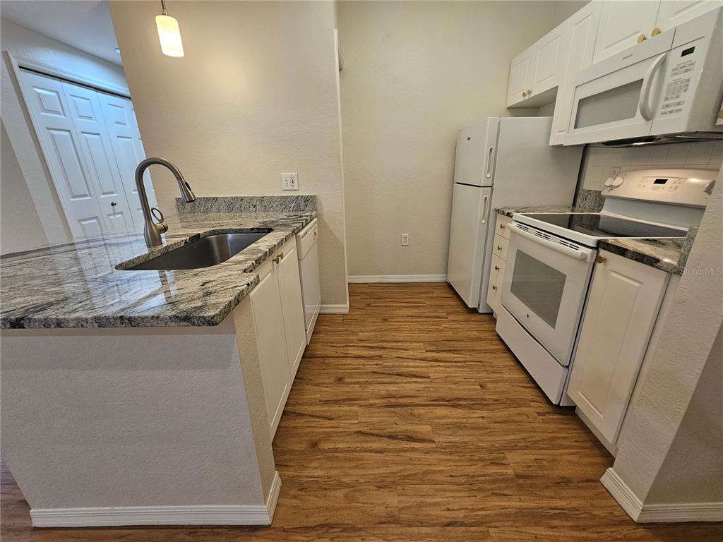 5174 Northridge Road, Unit 209 Sarasota, FL 34238 - Photo 7 of 25 a kitchen with a sink a stove and refrigerator