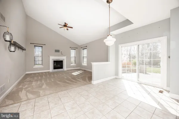 a view of an empty room with a window and fireplace