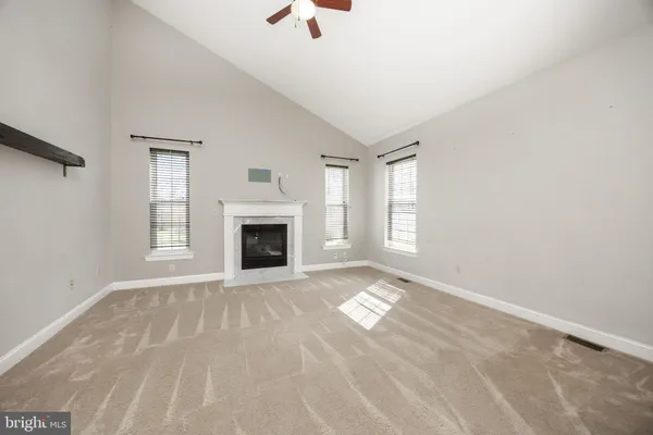 a view of an empty room with window and fire place