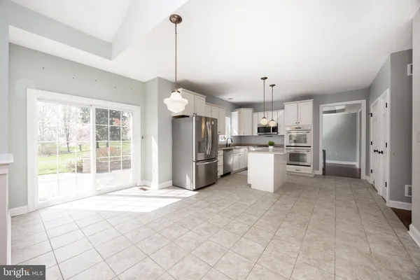 a large kitchen with stainless steel appliances granite countertop a stove a sink a refrigerator and a granite counter tops