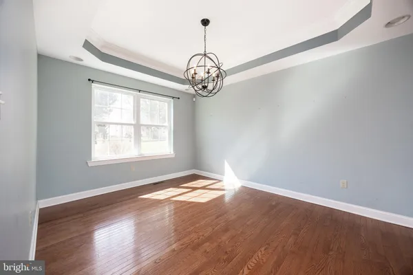 a view of a room with wooden floor fan and windows