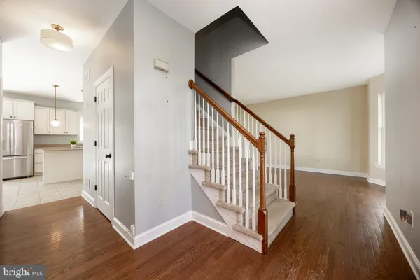 a view of a hallway with wooden floor and staircase