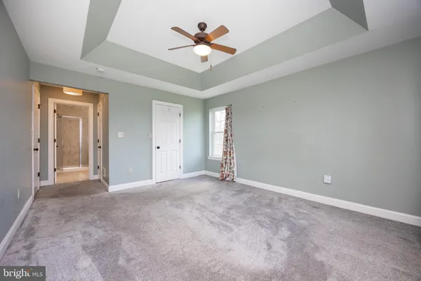 wooden floor in an empty room with a ceiling fan