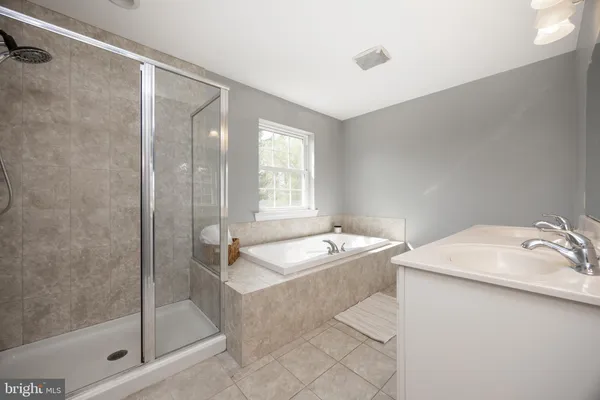 a bathroom with a tub sink and mirror