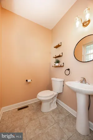 a bathroom with a sink a toilet and mirror