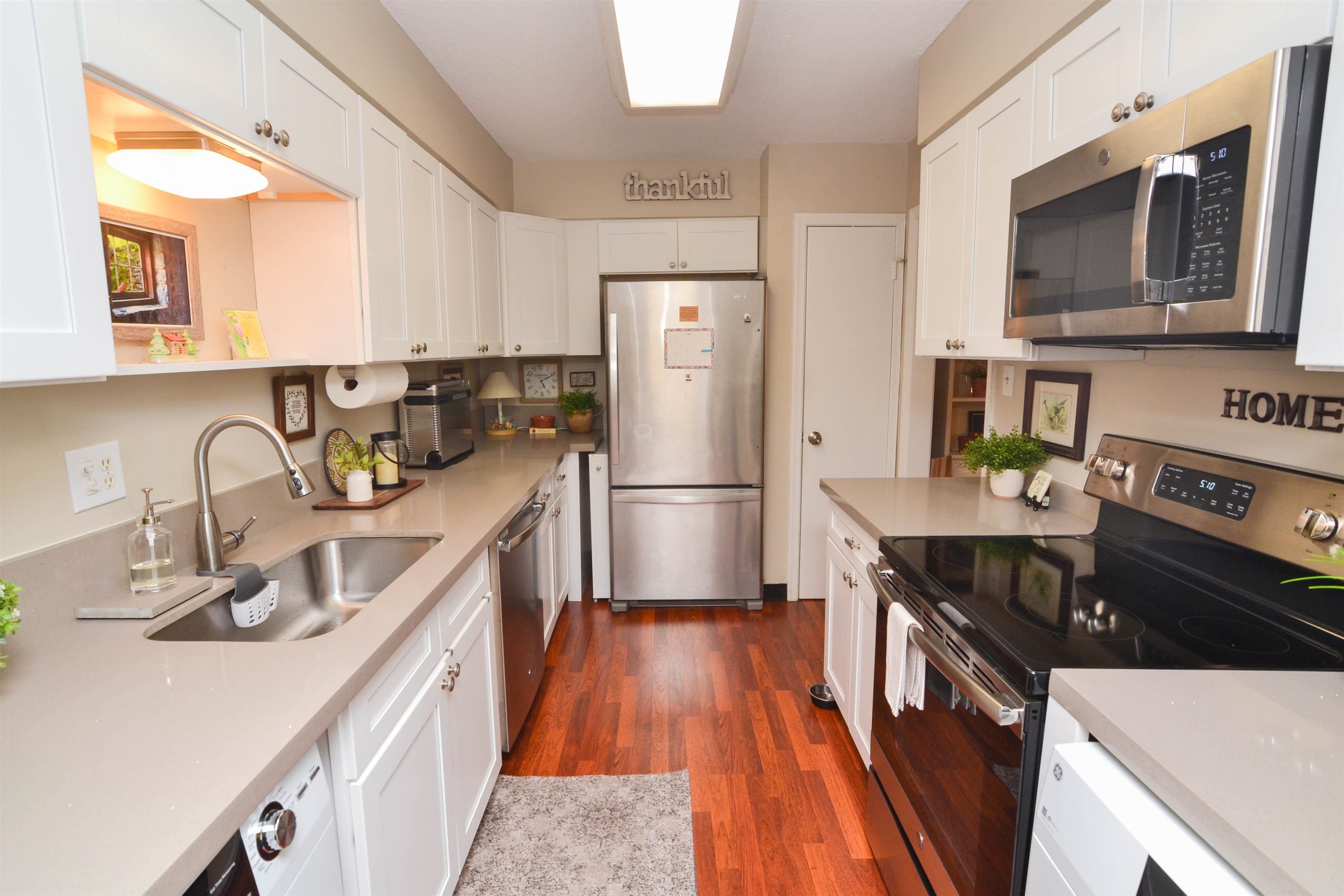 5676 Quince Road, Unit 11 Memphis, TN 38119 - Photo 9 of 22 a kitchen with stainless steel appliances granite countertop a refrigerator a stove a sink dishwasher and microwave with wooden floor