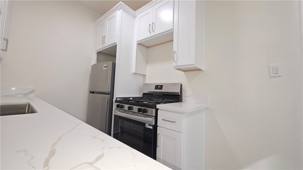 33408 Sunset Los Angeles, CA 90026 - Photo 8 of 11 a kitchen with stainless steel appliances a stove a microwave and cabinets