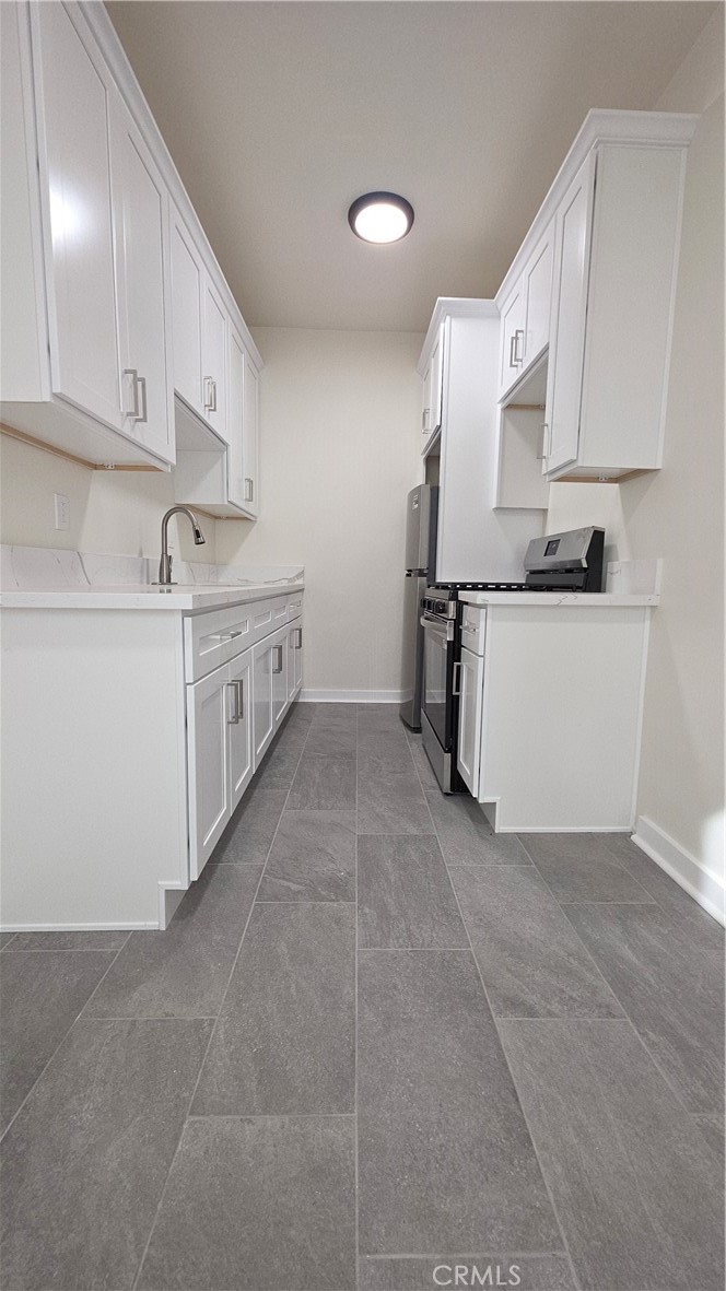33408 Sunset Los Angeles, CA 90026 - Photo 10 of 11 a kitchen with stainless steel appliances a sink stove and cabinets