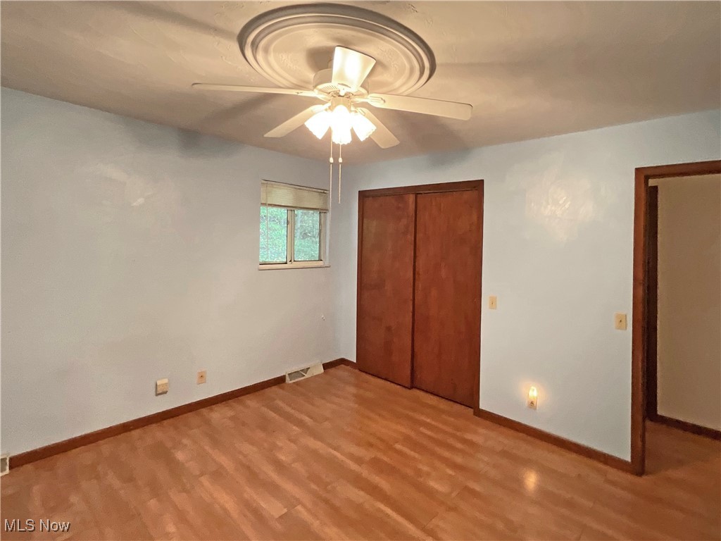 6568 Wylie Ridge Road New Cumberland, WV 26047 - Photo 10 of 28 Unfurnished bedroom featuring light hardwood / wood-style floors, ceiling fan, and a closet